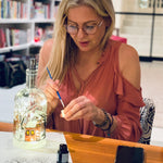 A lady paints her own bottle (winter village kit shown). Paint night kits are built based on the size of group.